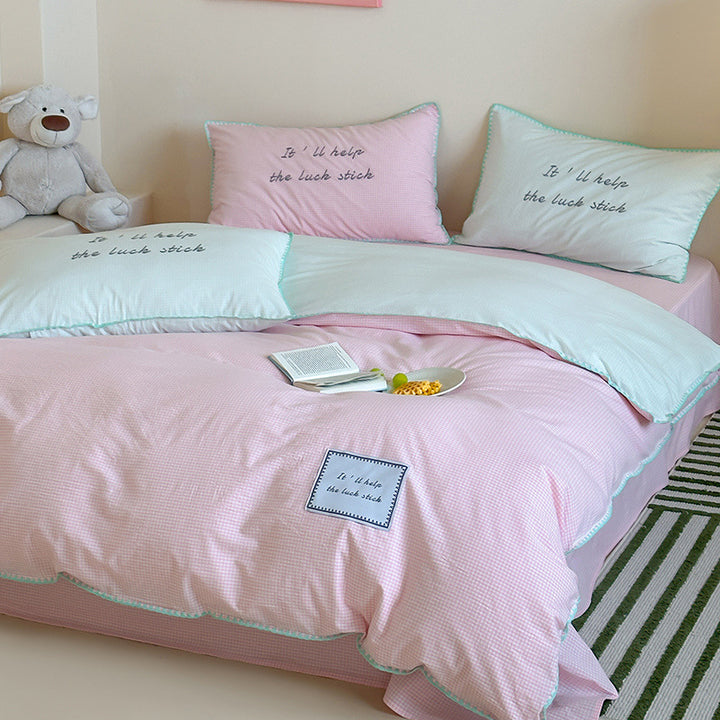 Striped cotton bedding set with subtle slogan appliqués and decorative piping