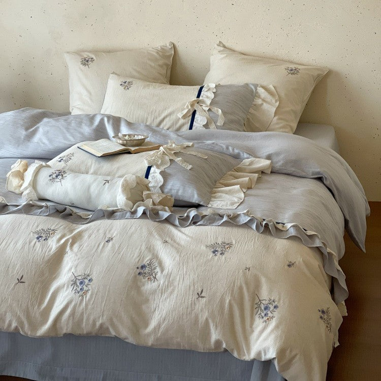 Romantic cotton satin bedding set with ruffles, embroidered flower bouquets, and decorative rolls Stornfield