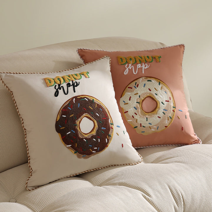 Square decorative cushion with embroidered donut motif and decorative piping edge