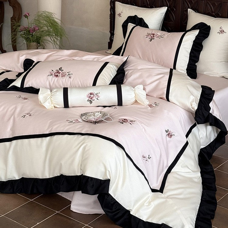 Luxurious embroidered bed linen set made of cotton satin with ruffles and decorative pillows