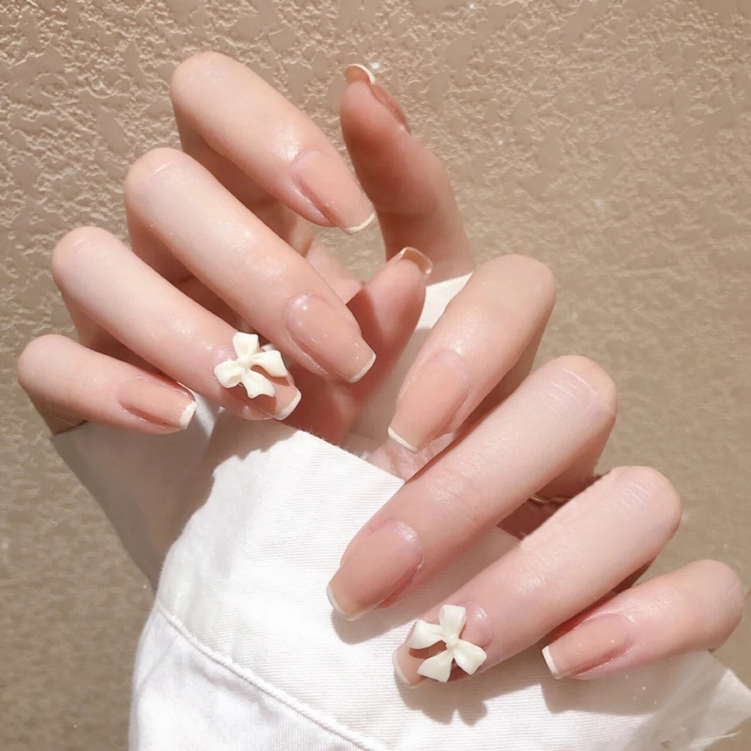 Artificial nails with elegant bow accents and pearl decorations Stornfield