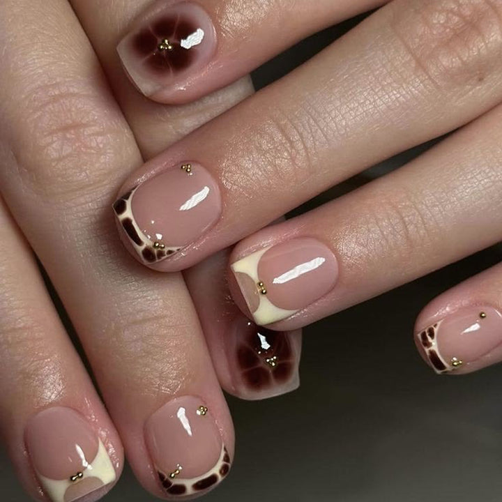 Artful nail extensions with an elegant giraffe pattern and golden accents Stornfield