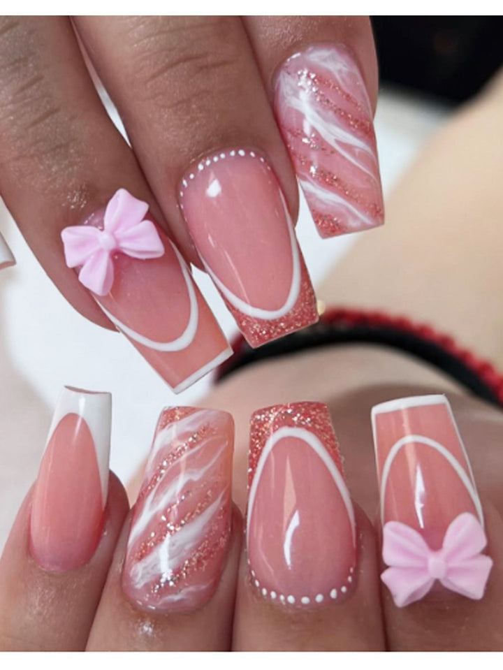 Acrylic nail set with elegant glitter design and playful bow accents Stornfield