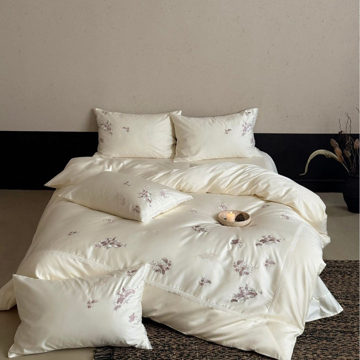 Satin bedding set with subtly embroidered flowers and lace trim