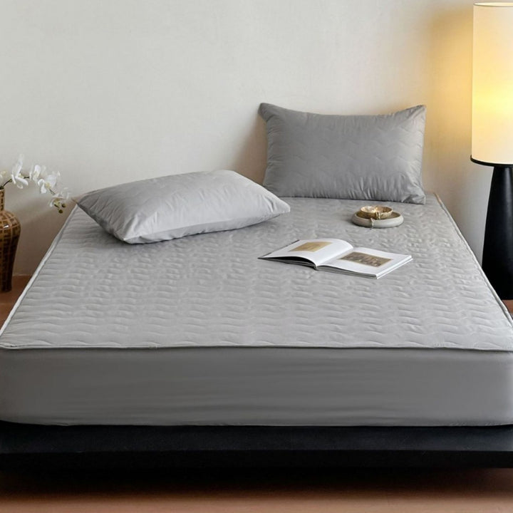 Padded mattress protector with all-round stretch and quilting