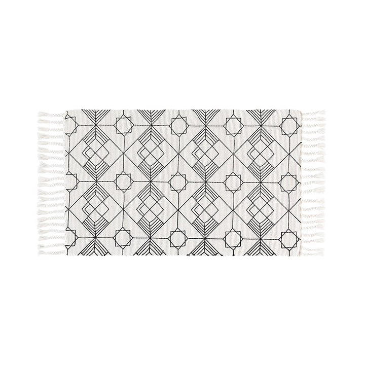 Flat-woven cotton table runner in Art Deco geometry jacquard with hand-fringed edge