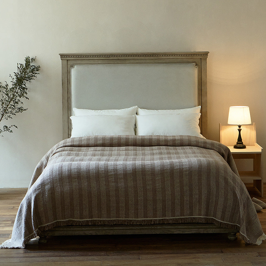 Massive wooden bed with upright slatted headboard and natural linen bedding
