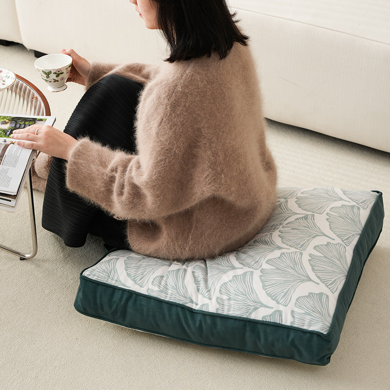 Padded floor cushion with quilted tufting, floral motif and carrying handle