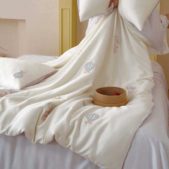 Premium children's bedding set made of cotton satin with pastel-embroidered balloon and carousel motifs.