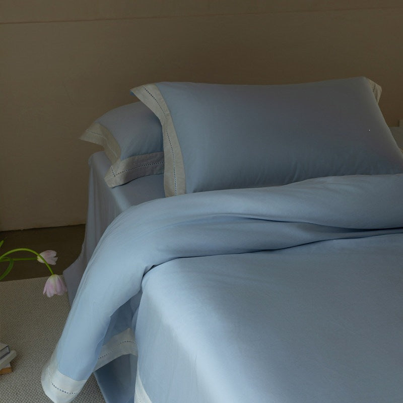 Fine cotton satin bedding set with contrasting linen border and decorative stitch trim