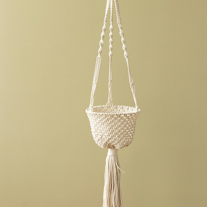 Macramé hanging planter with hand-knotted basket structure and decorative tassel