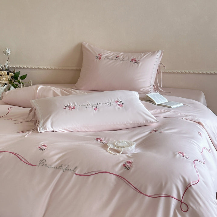 Elegant satin bedding with delicate rose embroidery and tie band detail