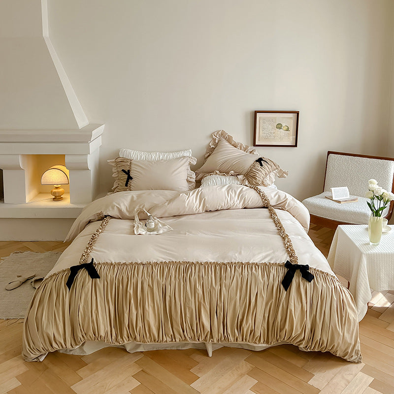 Luxurious satin bedding set with gathered ruffle, braided decorative ribbons and bow appliqué