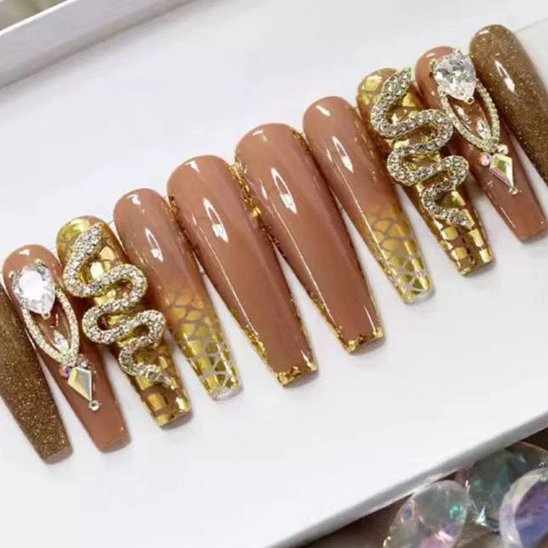 Exclusive stiletto artificial nails with glitter and jewelry accents Stornfield