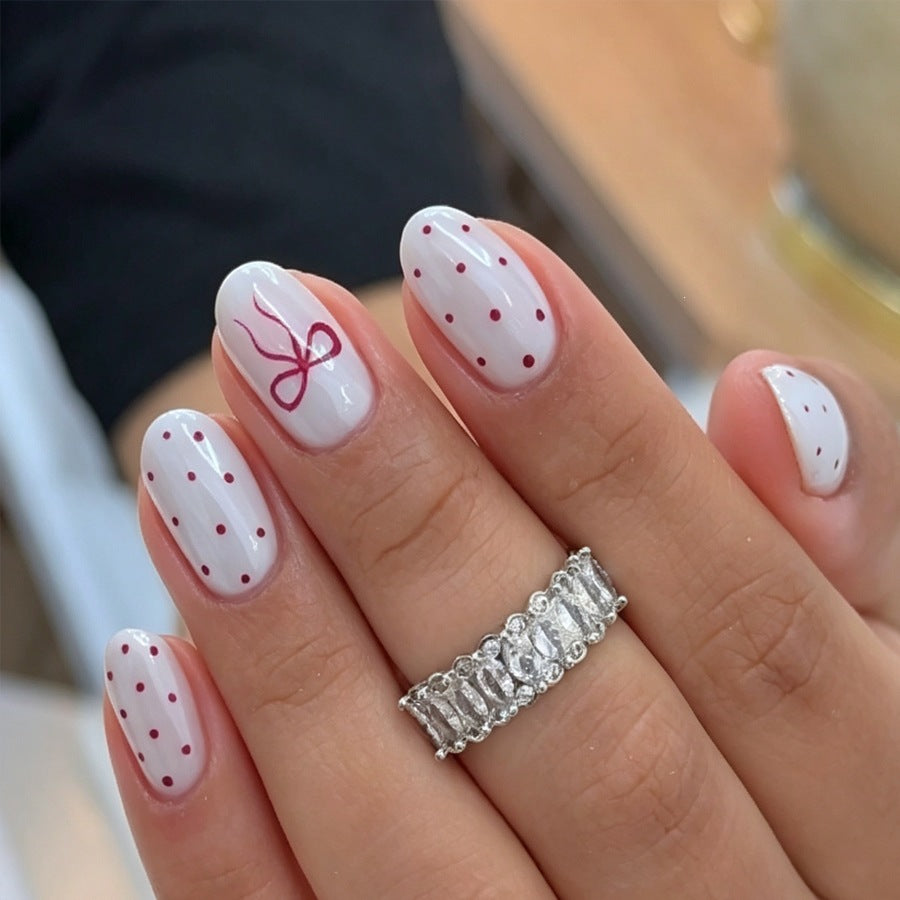 Artificial nail set with delicate dots and bow pattern Stornfield