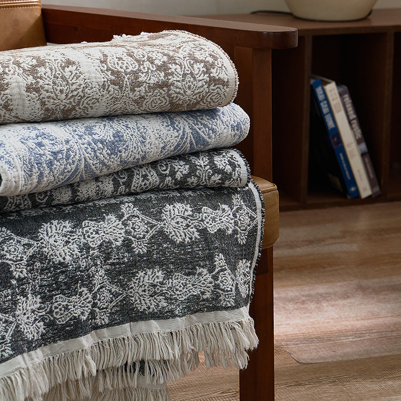 Large cozy living blanket made of cotton blend fabric with geometric jacquard pattern and fringed hem