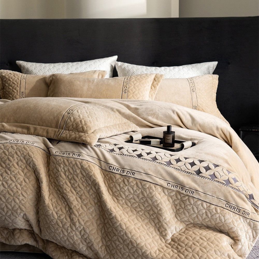 Quilted bedding set with geometric quilting and decorative ribbon