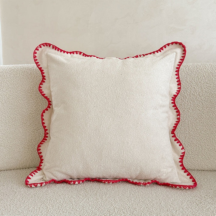 Decorative velvet cushion with wavy edge and decorative stitching