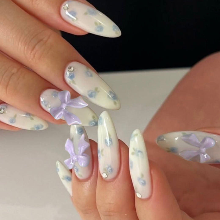 Artful stiletto nails with delicate flower patterns and glitter accents Stornfield