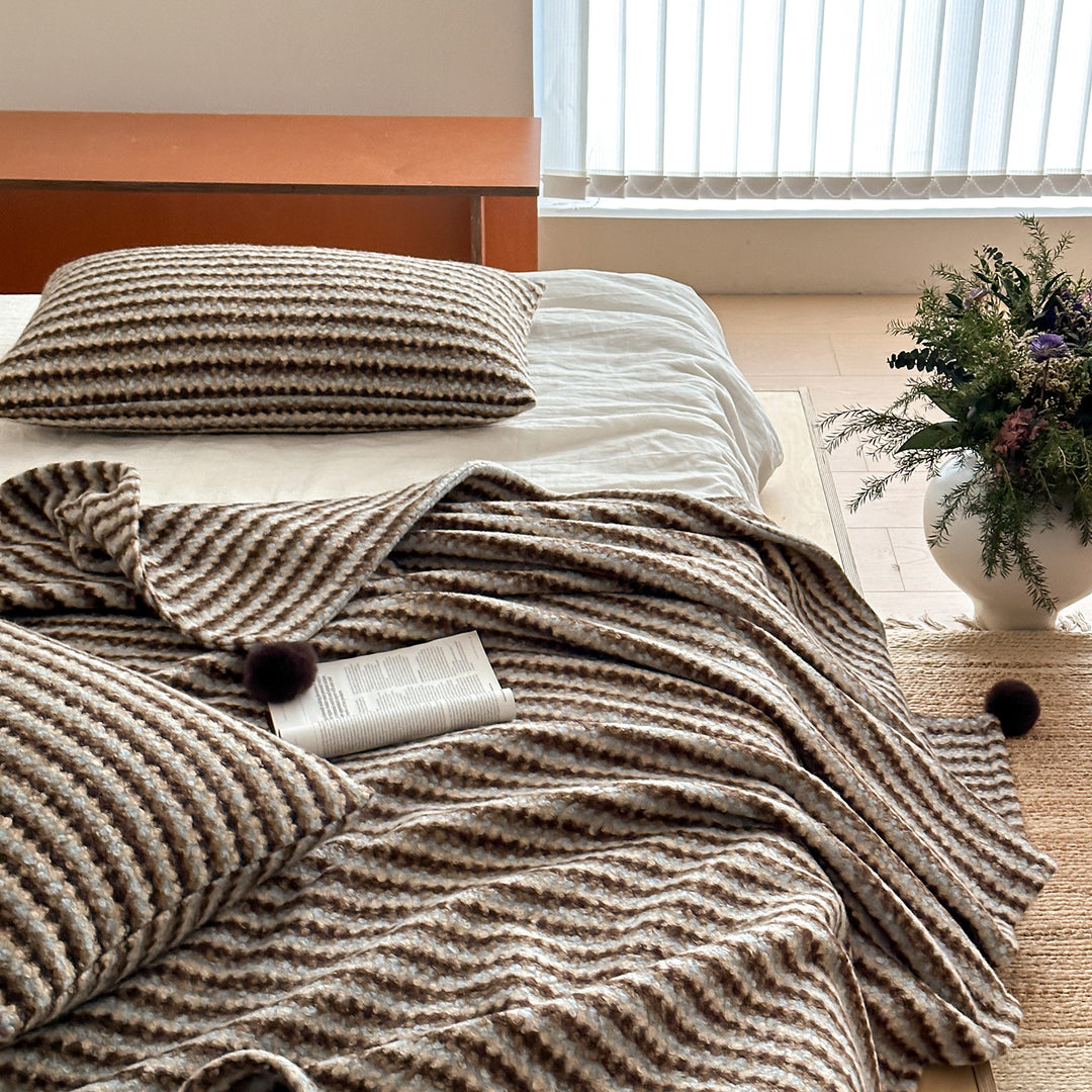 Cozy living blanket with waffle structure and pom-pom cushion set