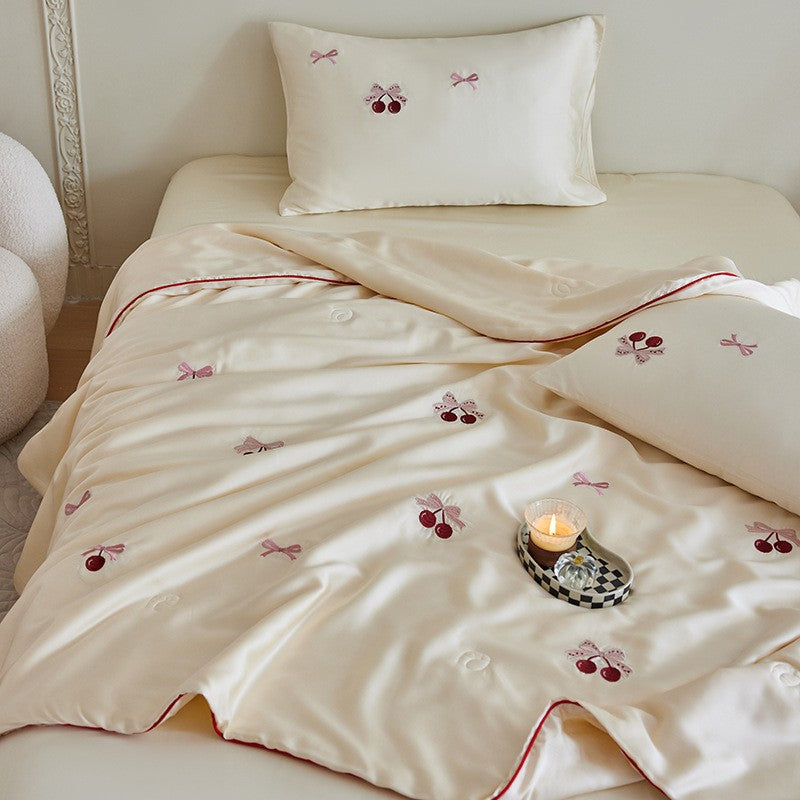 Luxurious satin bed linen set with embroidered Christmas tree motifs and contrasting piping
