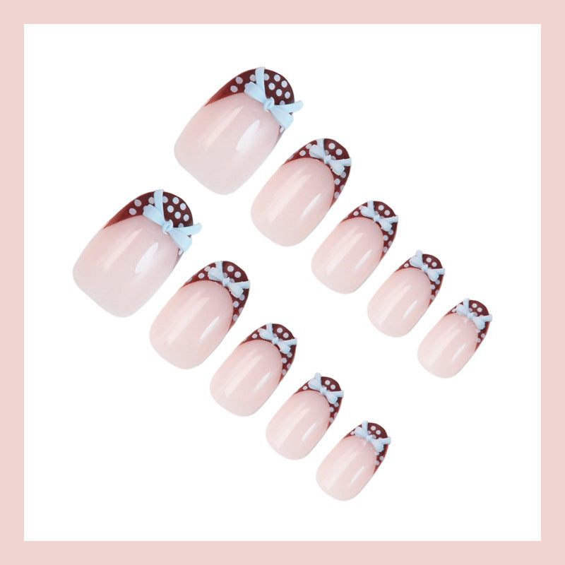 Artificial nail set with playful bows and elegant dots Stornfield