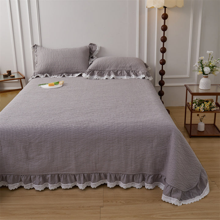 Quilted bed cover set with ruffled hem and lace trim