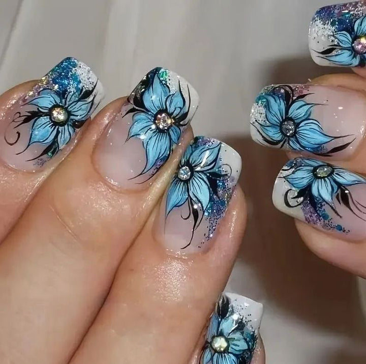 Artificial nail set with intricate floral designs and glitter elements Stornfield