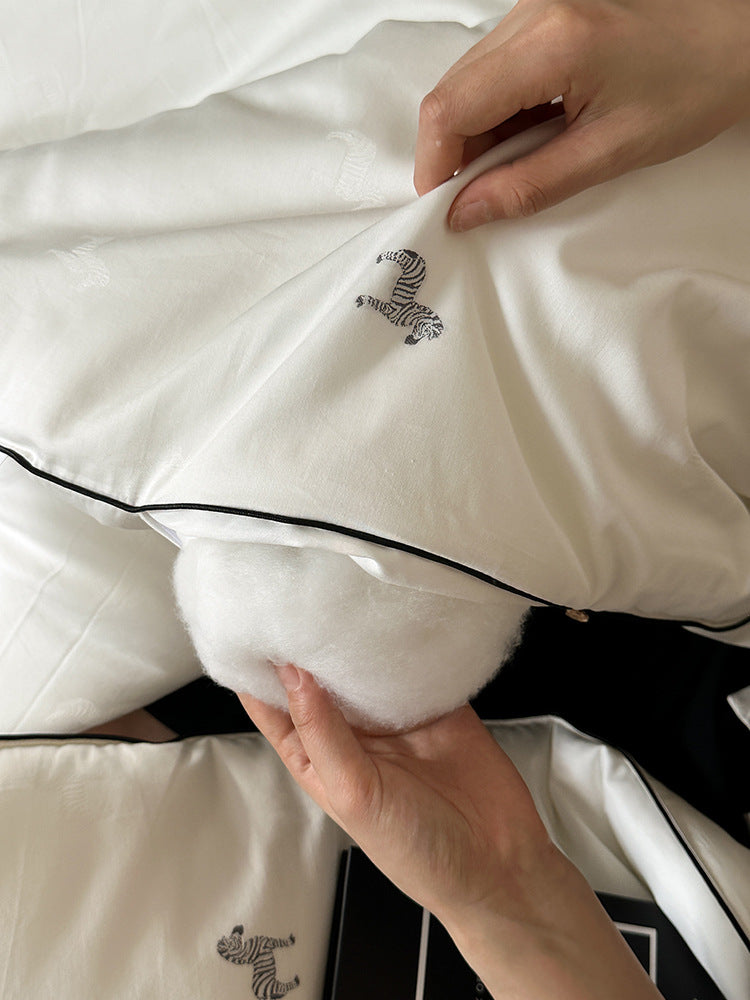 Light-warming cassette comforter with hollow fiber filling and fine tonal embroidery