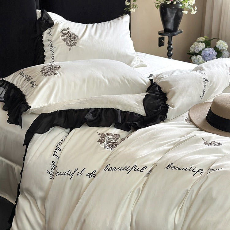 Bedding set made of silky-soft cotton satin with ruffle, delicate rose embroidery, and decorative lettering