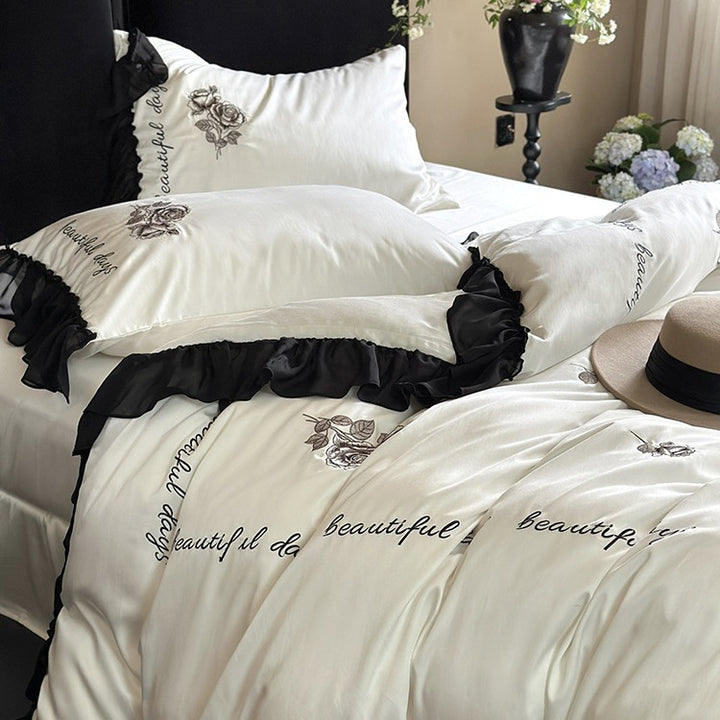 Bedding set made of silky-soft cotton satin with ruffle, delicate rose embroidery, and decorative lettering