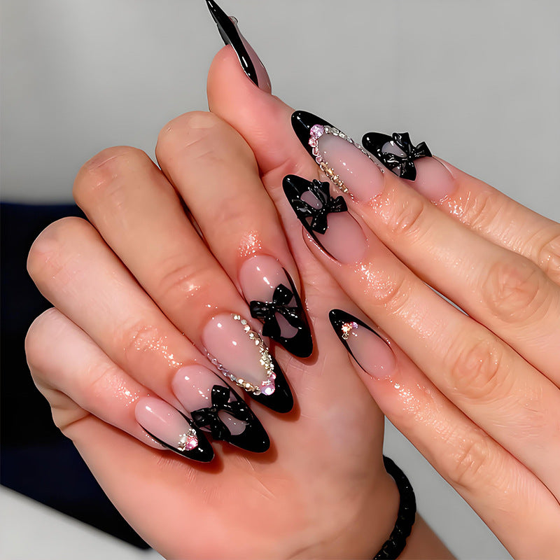 Artificial nail set with glamorous bow design and sparkling accents Stornfield