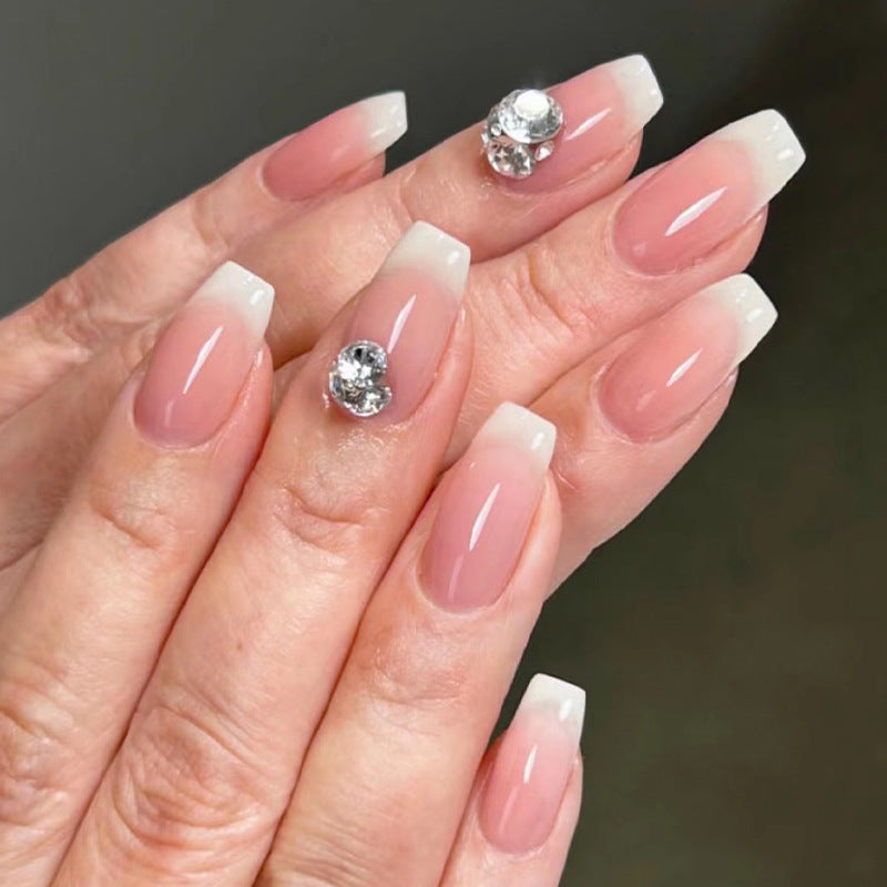 Artful nail extensions with elegant French tip and rhinestone embellishments Stornfield