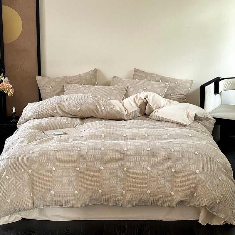Luxurious cotton bedding set with textured waffle appearance and pompom details