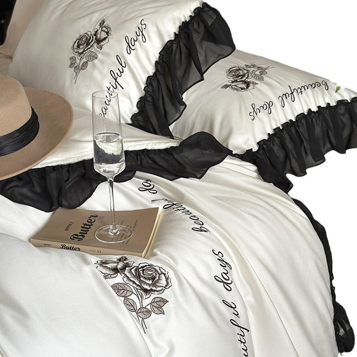 Bedding set made of silky-soft cotton satin with ruffle, delicate rose embroidery, and decorative lettering