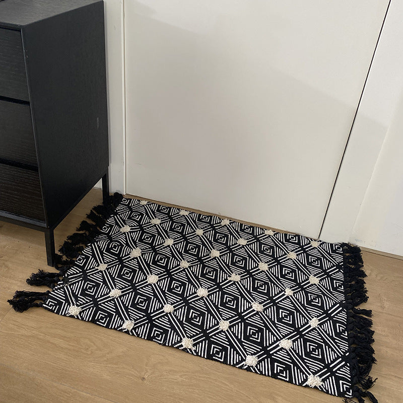 Hand-tufted bathroom mat with fringes, decorative dot-and-dash pattern and non-slip backing Stornfield