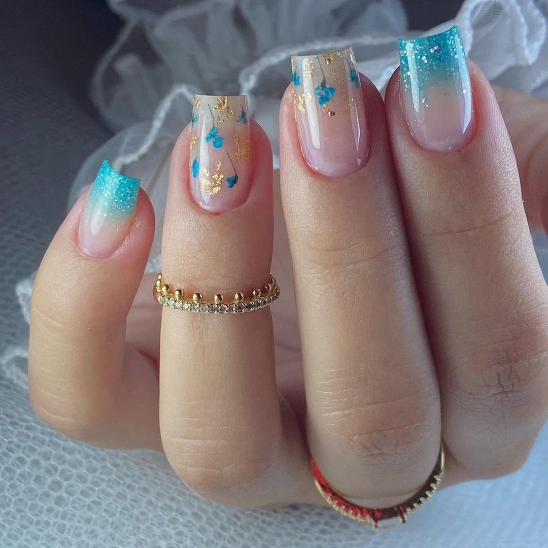 Artful acrylic nails with floral design and glitter effects Stornfield