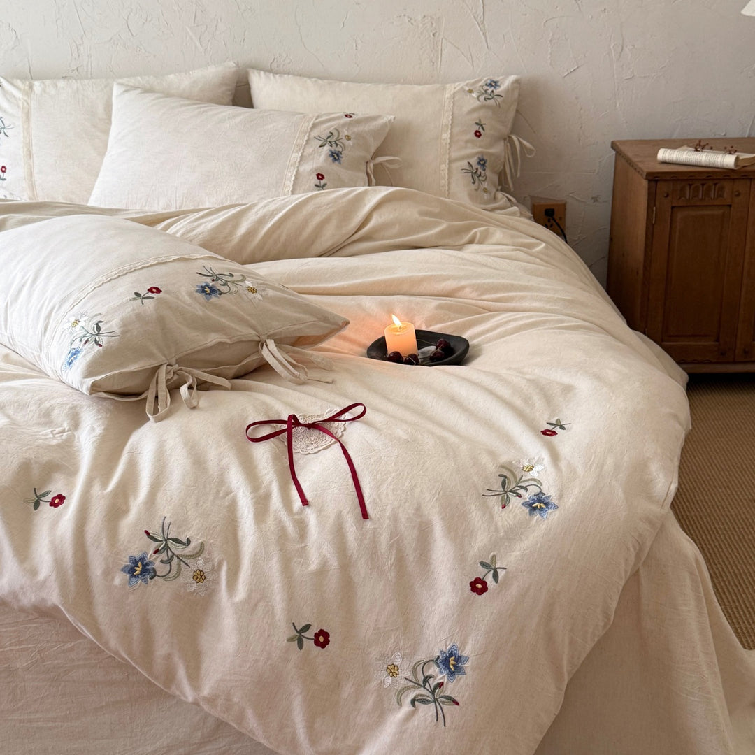 Romantic linen-cotton bedding set with delicate floral embroidery, tie loops and round cushion
