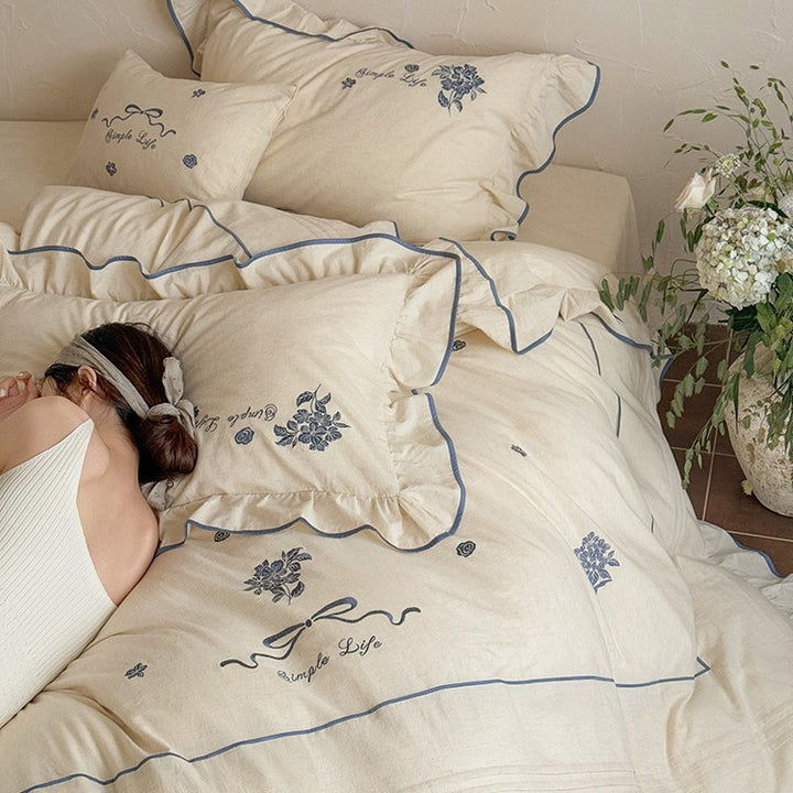 Cotton muslin bedding set with delicate floral embroidery, ruffle, and breathable finish