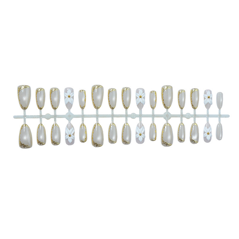 Acrylic nail set with elegant gold embellishments and floral accent Stornfield