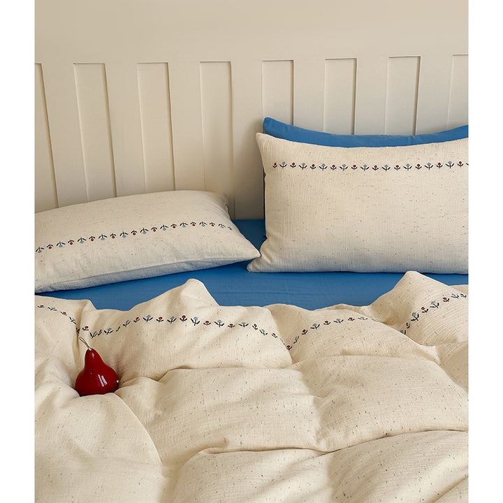 Cotton gauze bedding set with delicate border embroidery and mottled nep structure