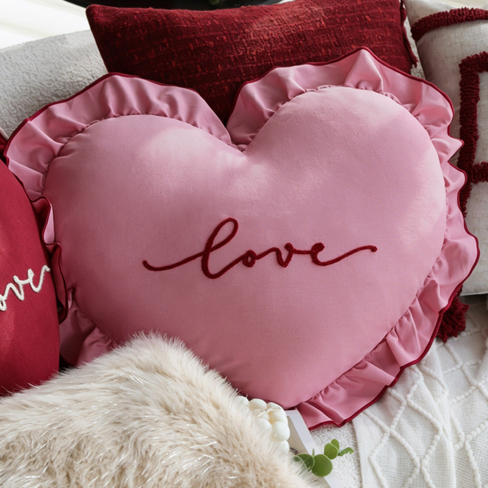 Heart-shaped decorative pillow with ruffled trim and embroidered inscription Stornfield