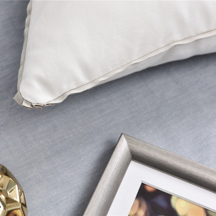 Comfort pillow with shape-stable hollow fiber filling and contrasting piping