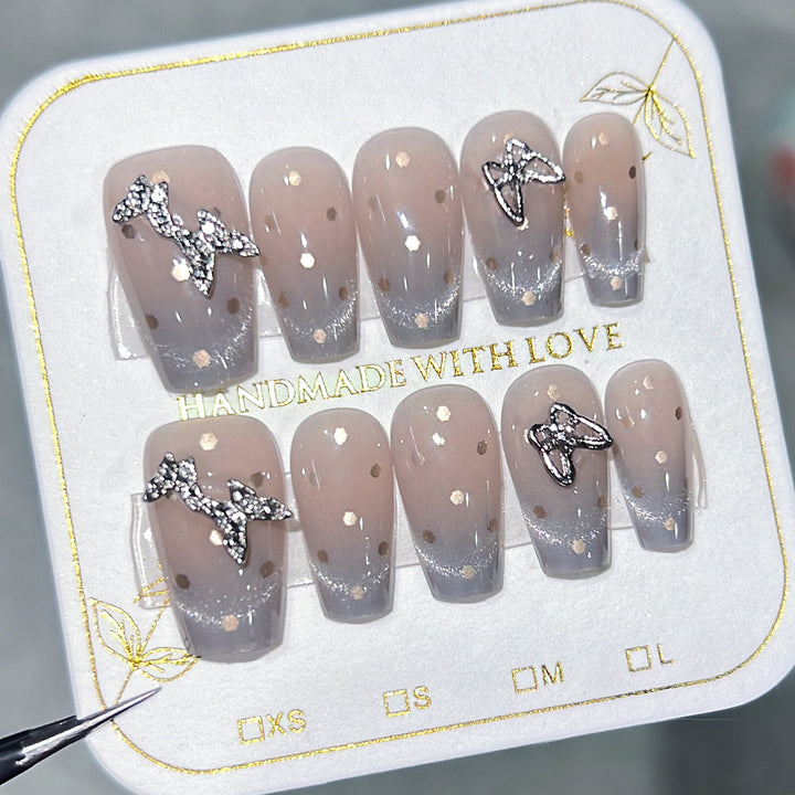 Artificial nail art with glitter details and bow accents Stornfield