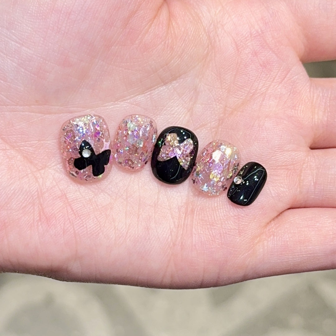 Artificial nails with glitter and bow accents Stornfield