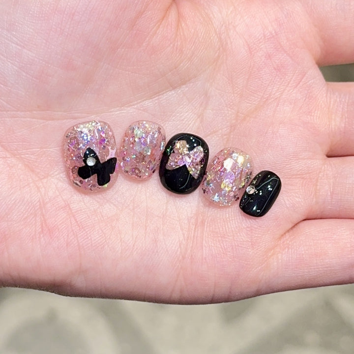 Artificial nails with glitter and bow accents Stornfield