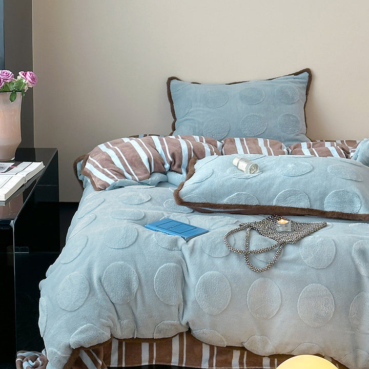 Plush bedding set with embossed floral relief and teddy trim