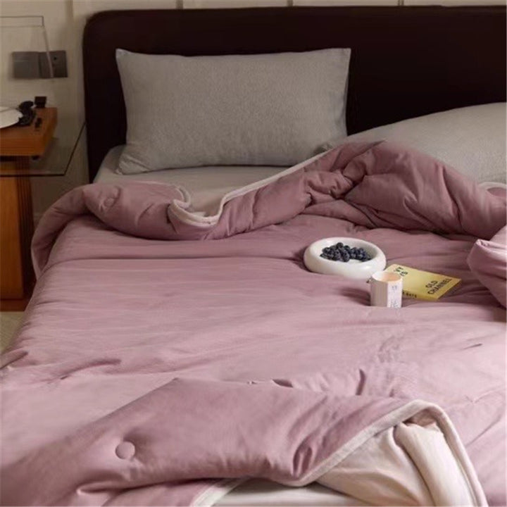 Light reversible quilted blanket made of microfiber with soft decorative stitching
