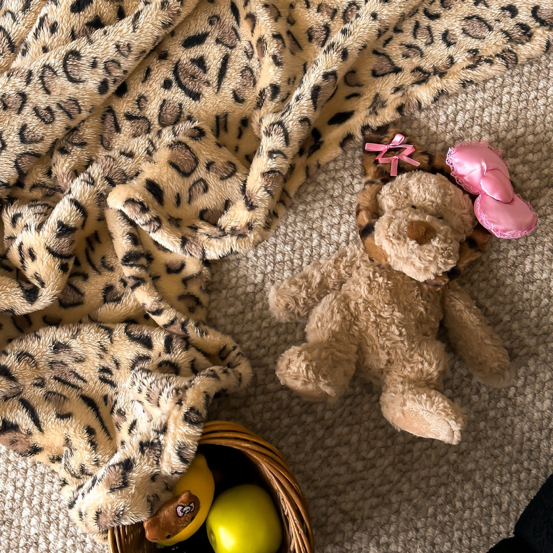 Cozy throw blanket made of microfleece with leopard print and plush pendants