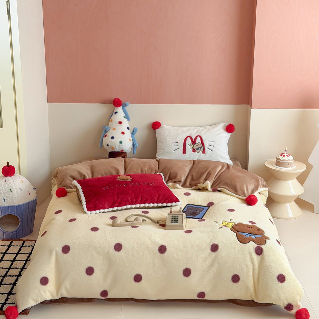 Plush bedspread with embroidered bear motif and pom-pom edge